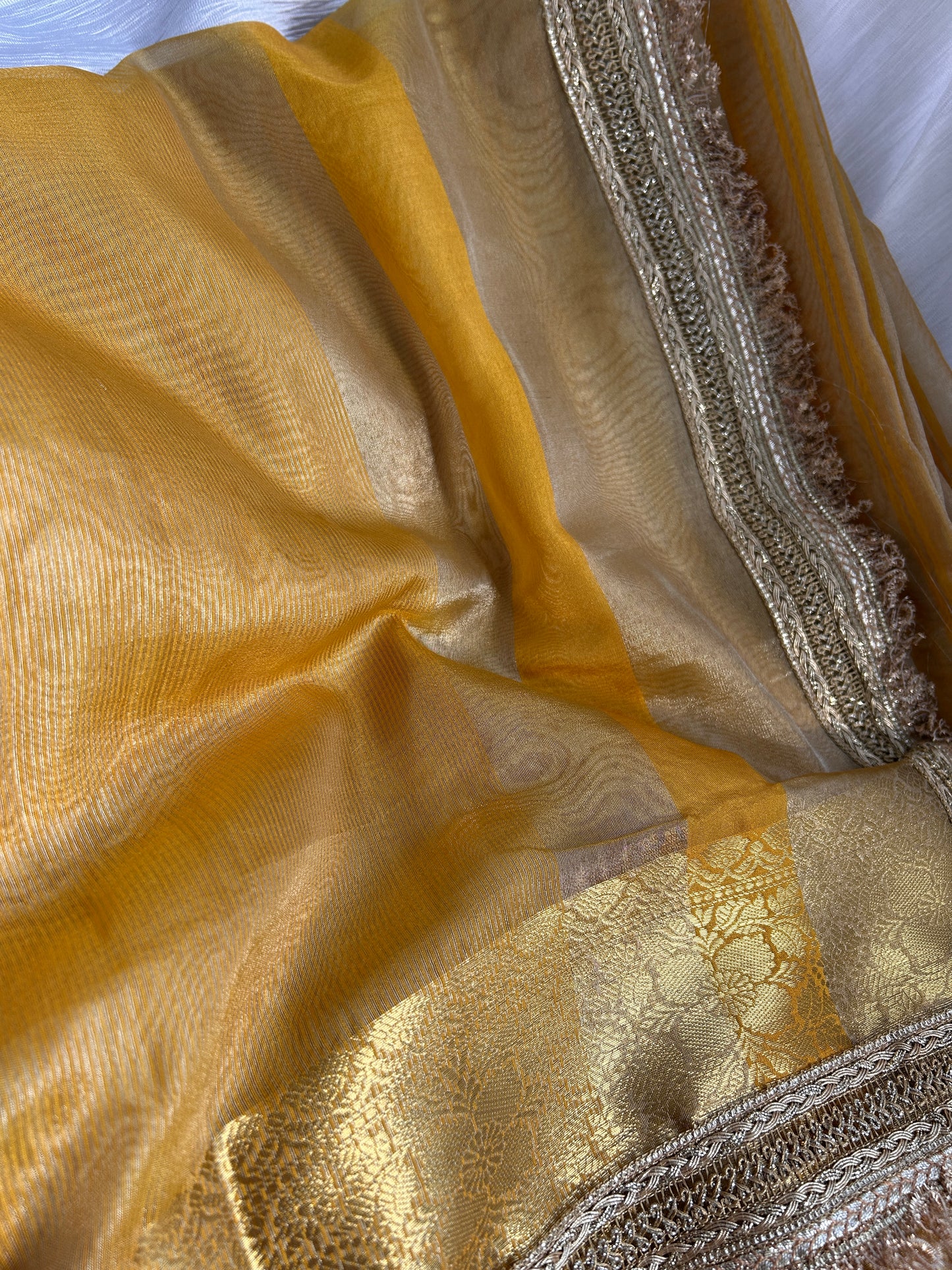 Close-up of gold fabric with intricate patterns and textures