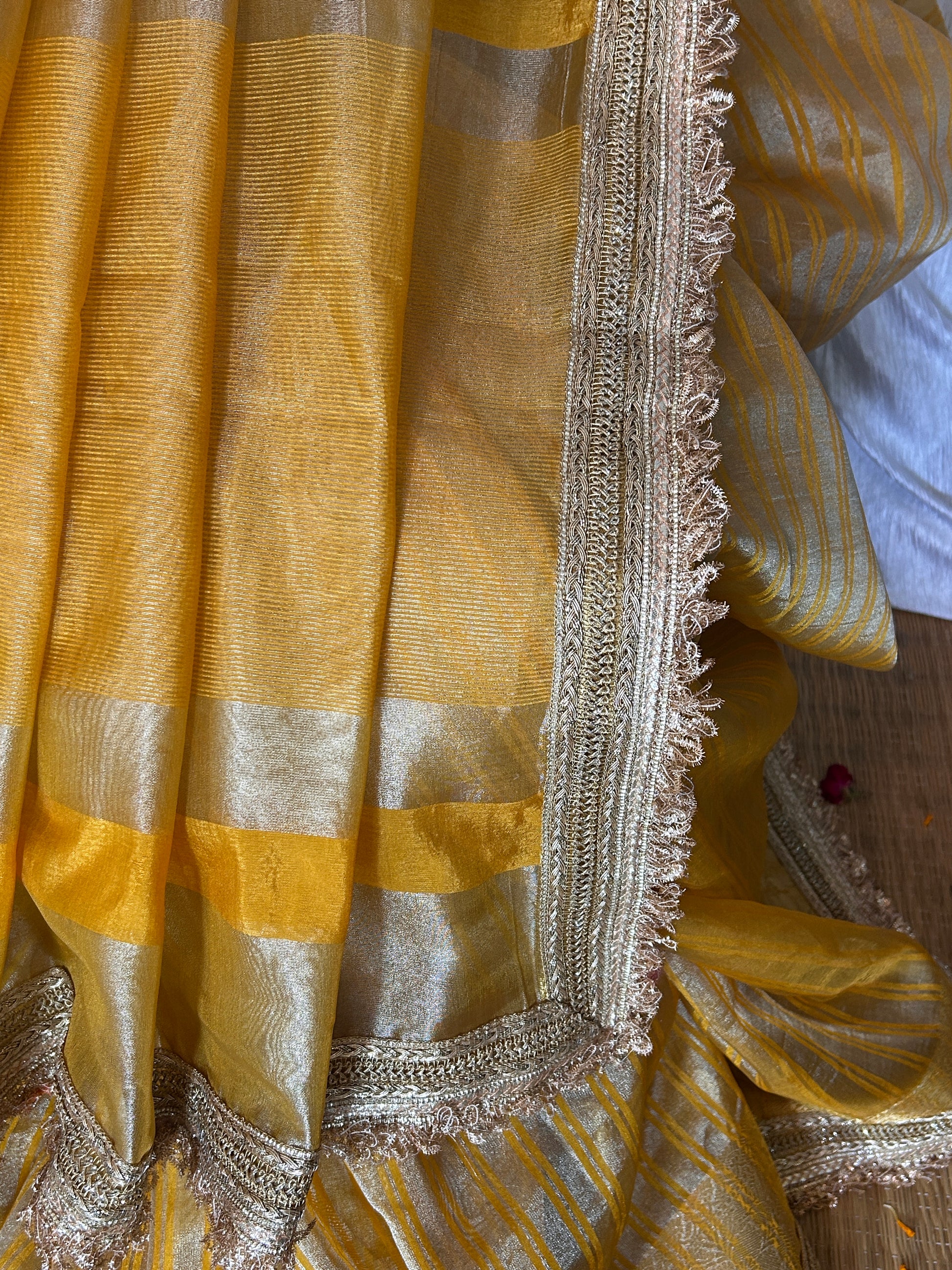 Close-up of a yellow fabric with silver border and patterns.